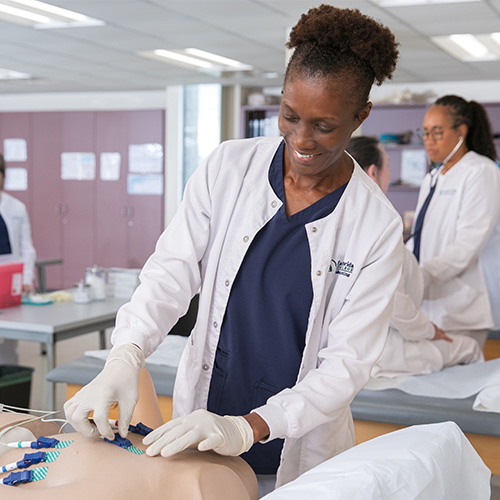 A woman in scrubs is working with phlebotomy tools
